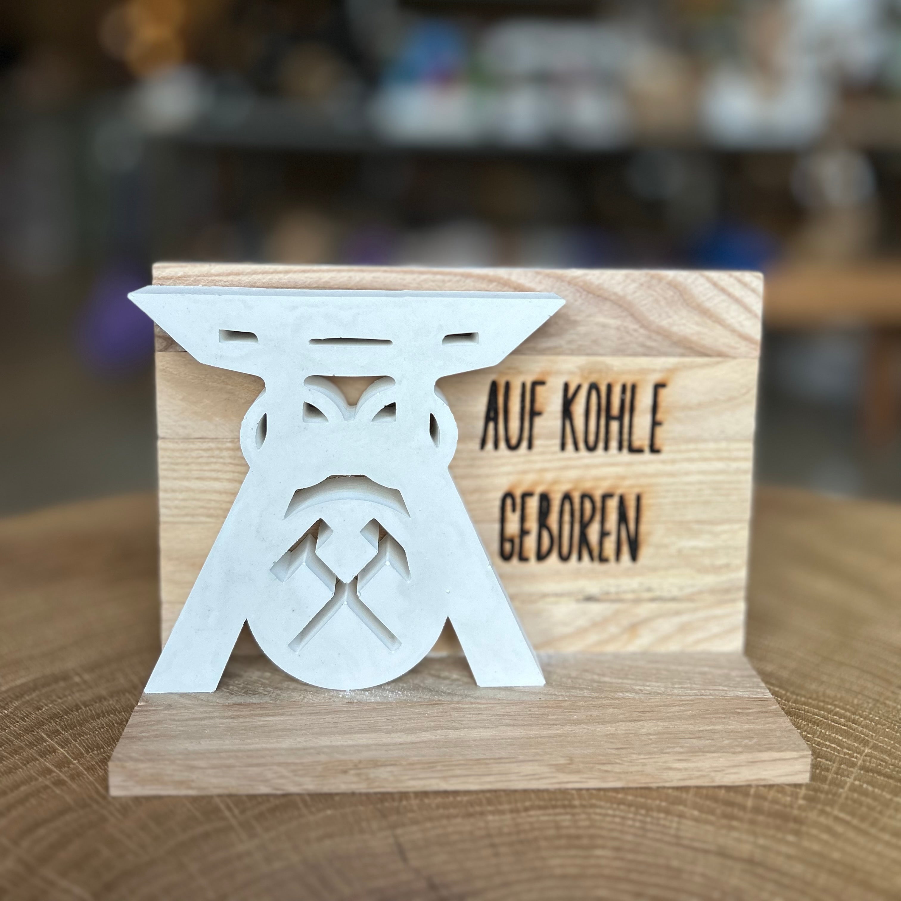 Deko-Schild Auf Kohle geboren aus Holz mit weißer Bergbau-Silhouette – stilvolle Ruhrpott Dekoration, Geschenkidee für Bergleute und Ruhrgebiet-Fans.