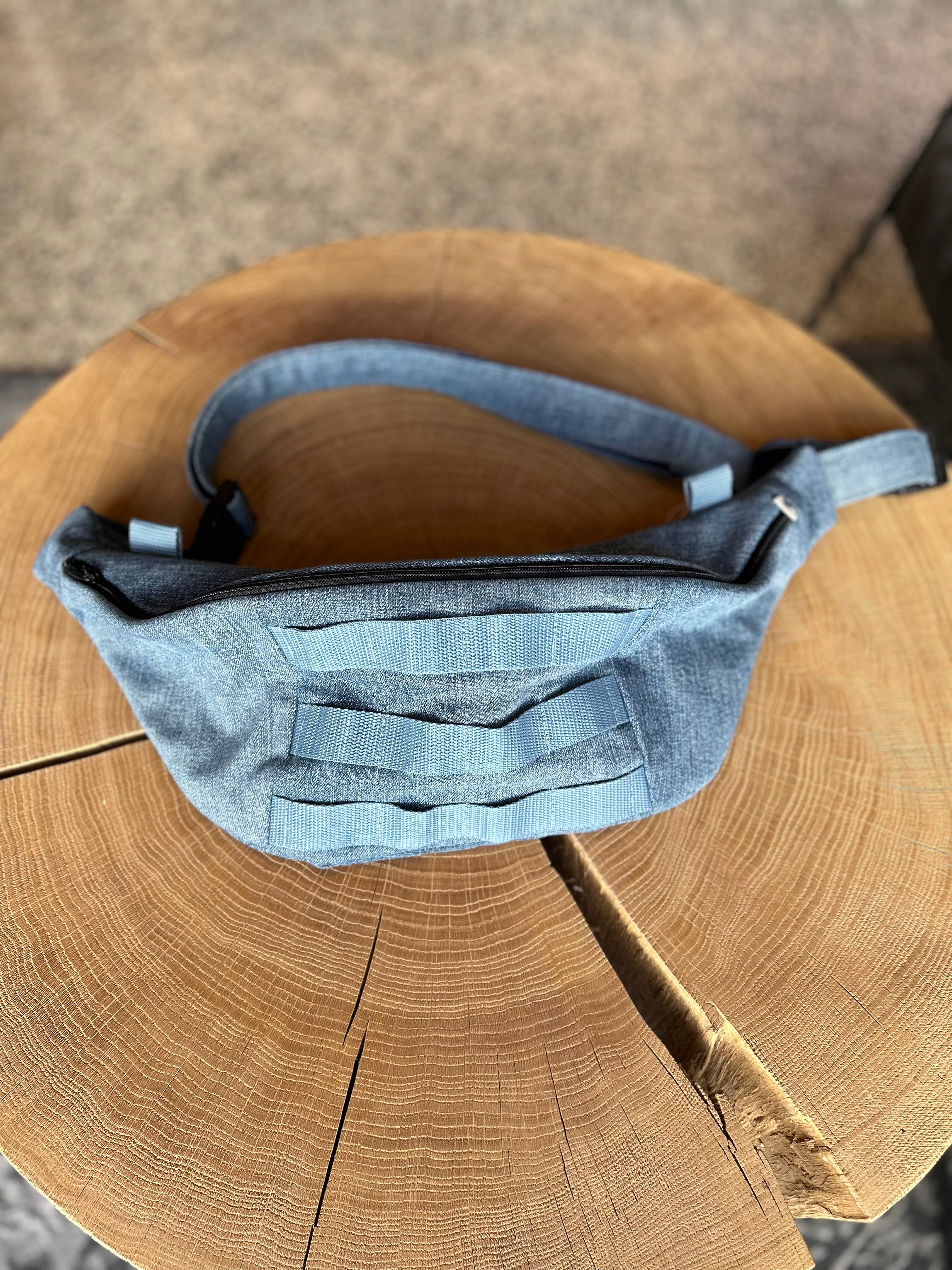 Jeans Bananentasche die auf einem Holztisch liegt