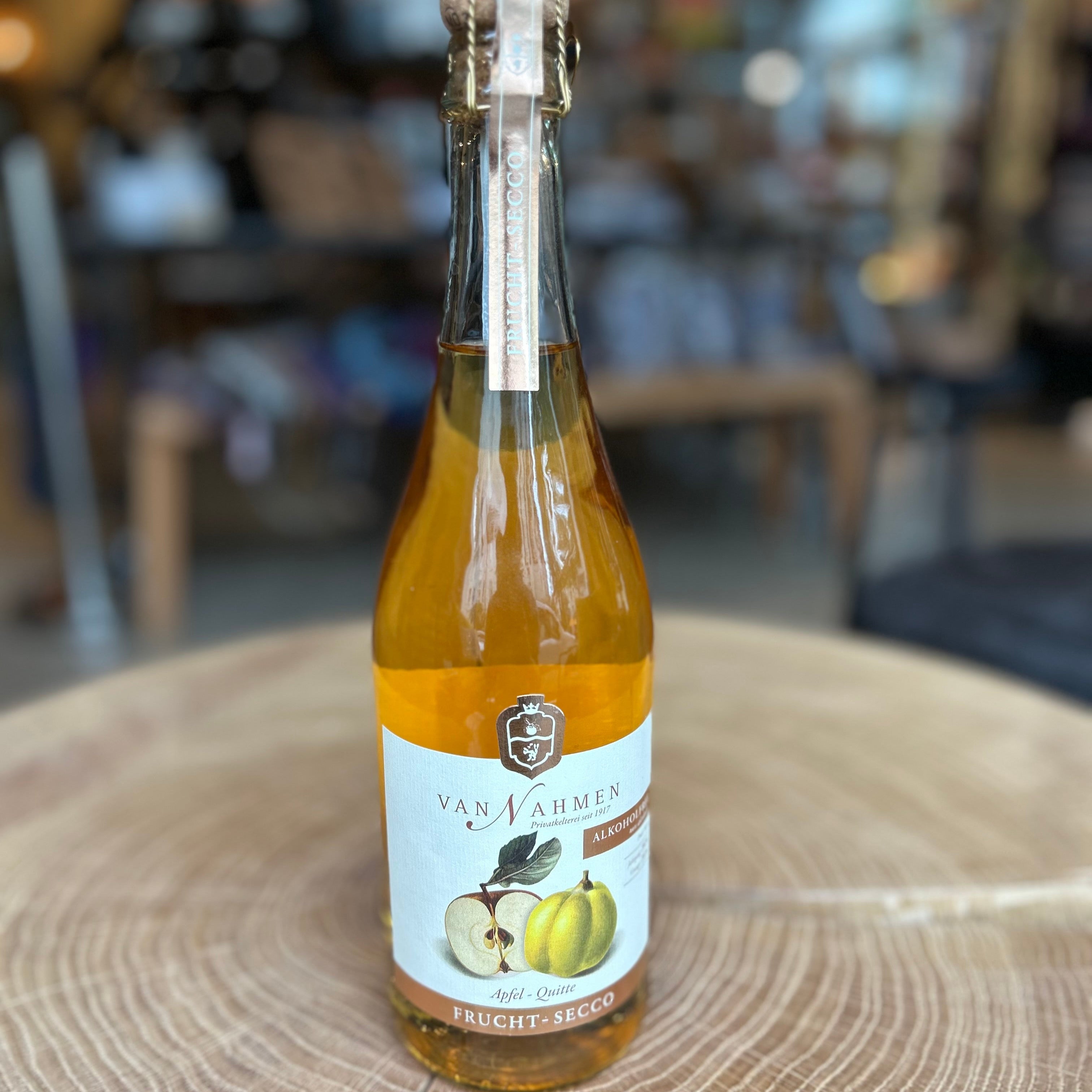 Van Nahmen frucht-secco alkoholfrei, Apfel-Quitte, stehend auf einem Holztisch