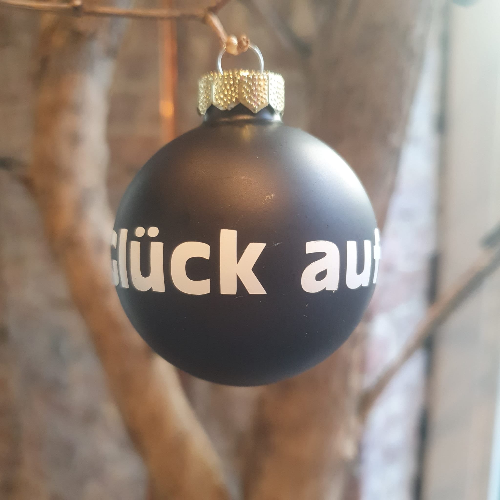 Ruhrpott Weihnachtskugel ‚Glück auf‘ – schwarze matte Glaskugel mit weißer Aufschrift, Bergbau-Design aus dem Ruhrgebiet. Erhältlich in verschiedenen Varianten: matt, glänzend. Perfekt als Geschenk oder Weihnachtsdeko für Ruhrpott-Fans.