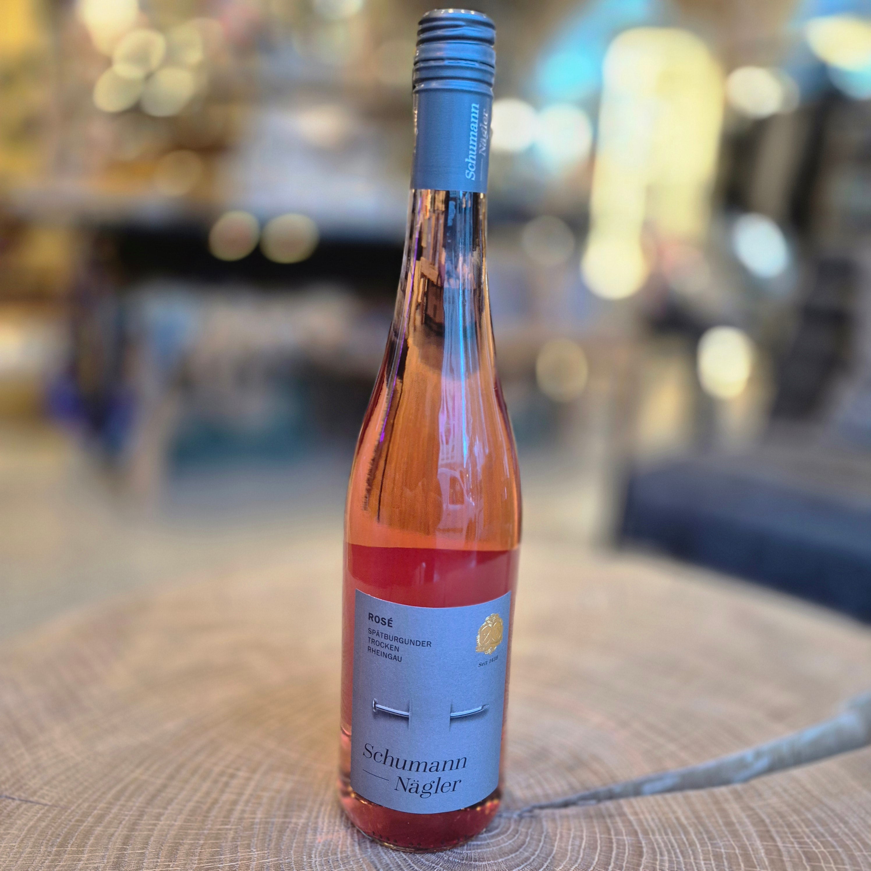 Schumann Nägler Spätburgunder Rosé trocken – elegante Weinflasche auf Holztisch. Deutscher Roséwein aus dem Rheingau mit fruchtigen Noten von Erdbeere und Himbeere, feiner Frische und harmonischer Struktur. Qualitätswein für Sommer und Genussmomente.