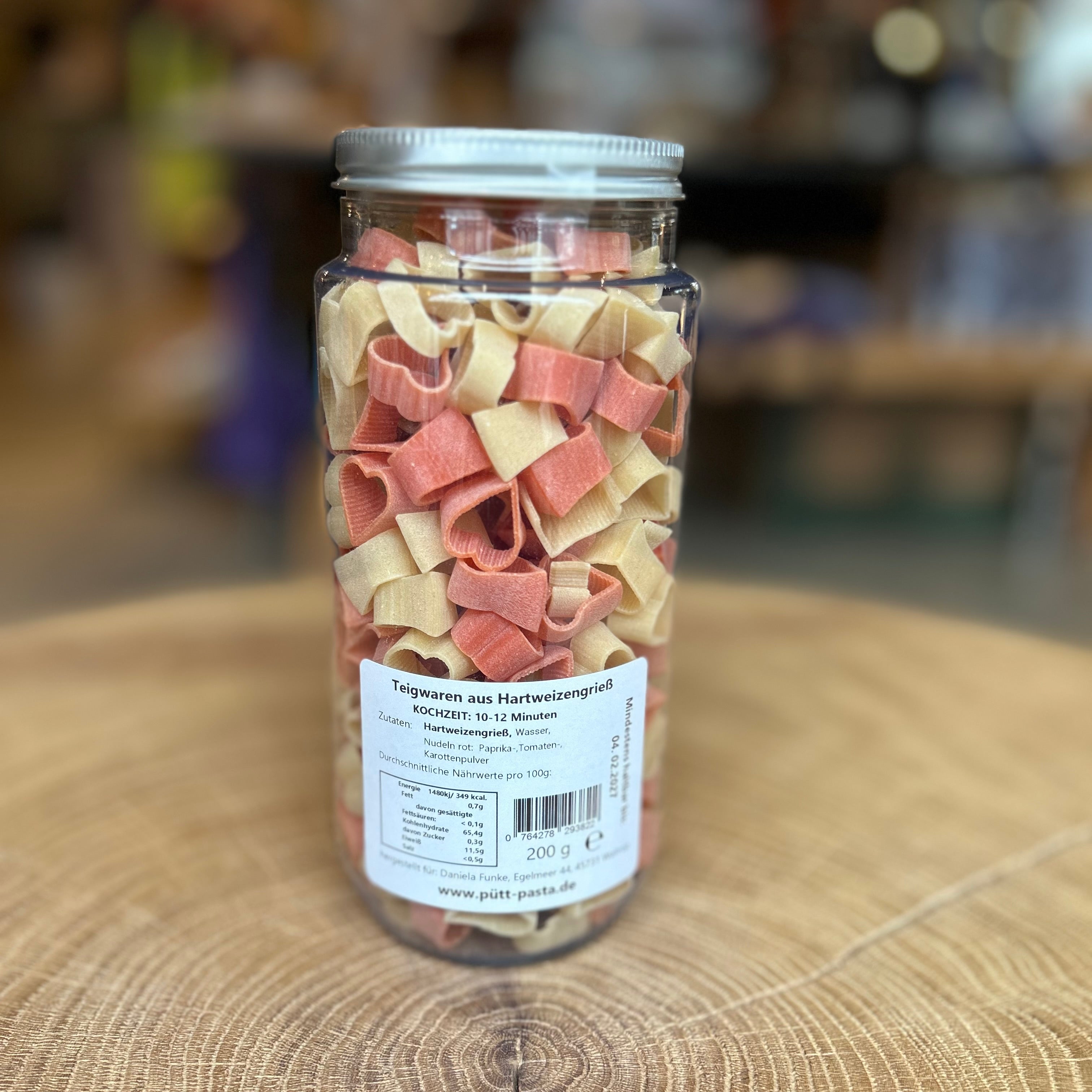 Herznudeln „Liebe isst“ im PET-Glas von Pütt Pasta – rote und naturfarbene Pasta in Herzform, 200 g, aus Hartweizengrieß, dekorativ verpackt, liebevolles Geschenk und nachhaltige Nudelspezialität aus dem Ruhrgebiet.