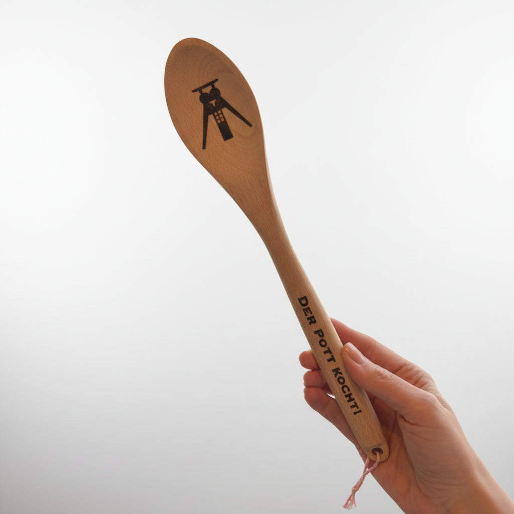 Holz-Kochlöffel mit Gravur „Der Pott kocht!“ und Bergbau-Symbol in der Hand gehalten – Ruhrpott Küchenutensil aus Holz als Geschenk für Kochfans und Ruhrgebiet-Liebhaber.