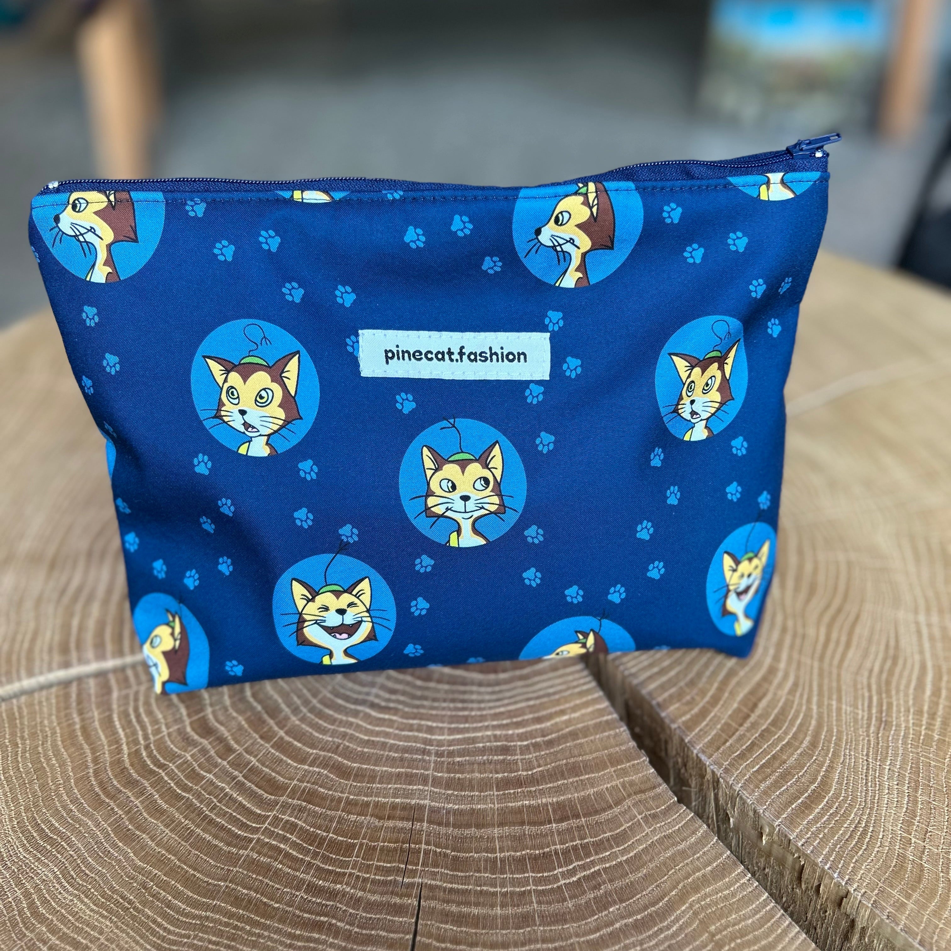 Große Kinder-Kosmetiktasche von Pinecat in Blau, verziert mit Katzen, stehend auf einem Holztisch