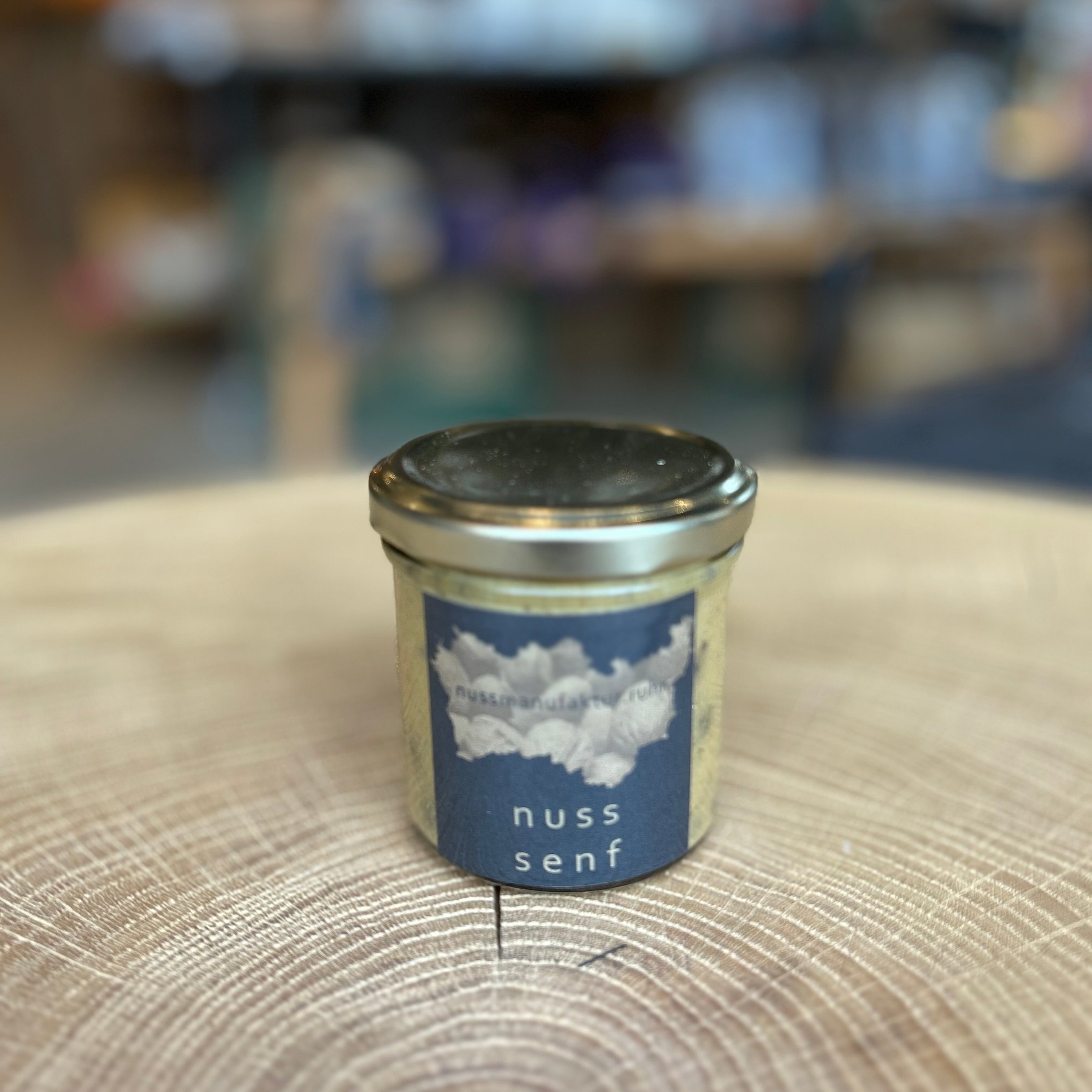 Feinkost Nuss Senf im Glas – cremiger Gourmet-Senf mit aromatischen Nussnoten, handgemacht und ideal zu Käse, Fleisch und Dressings. Hochwertiger Delikatessen-Senf im Schraubglas auf Holztisch.