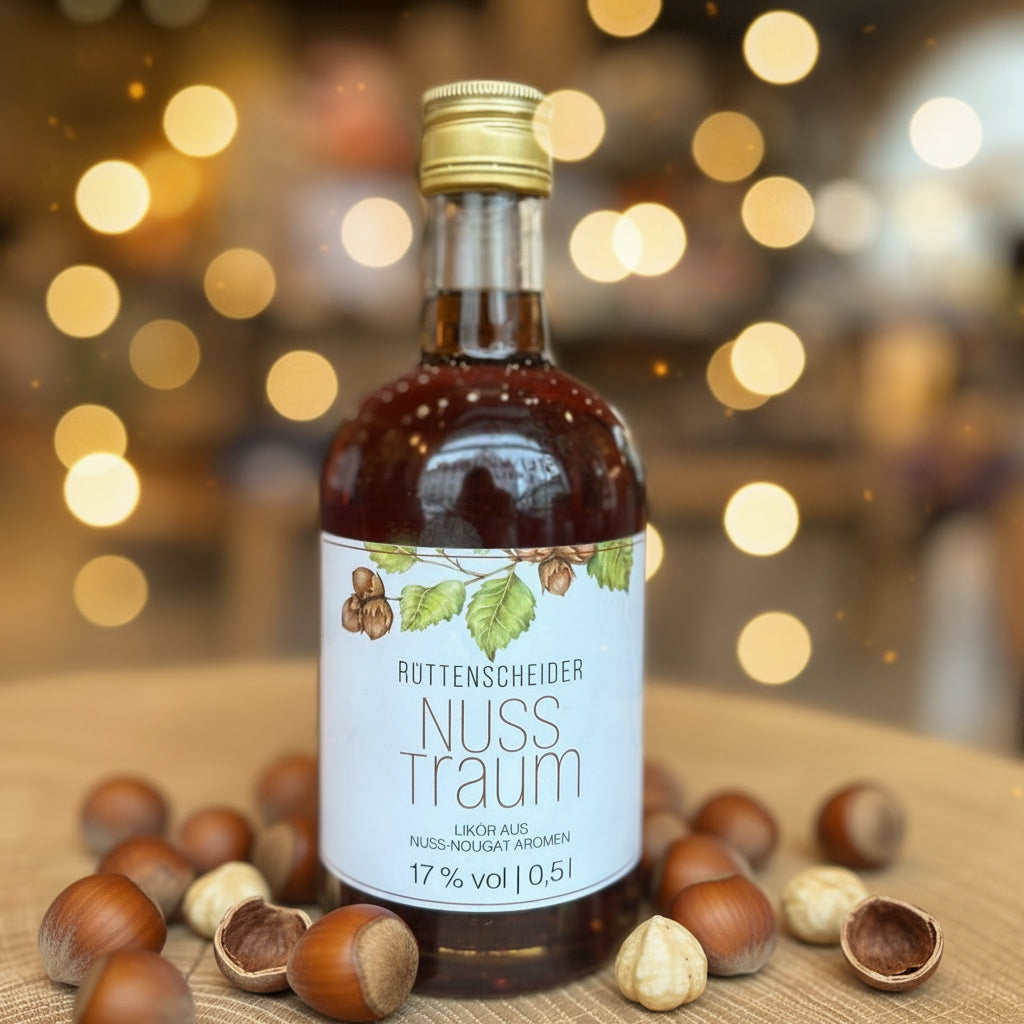 Flasche „Rüttenscheider Nuss Traum“ Likör (0,5 l, 17 % vol) auf einem Holztisch. Die braune Likörflasche trägt ein helles Etikett mit Haselnüssen und Blättern. Nuss-Nougat-Likör aus Essen-Rüttenscheid – ideal als Geschenk, Dessertlikör oder regionales Mitbringsel.