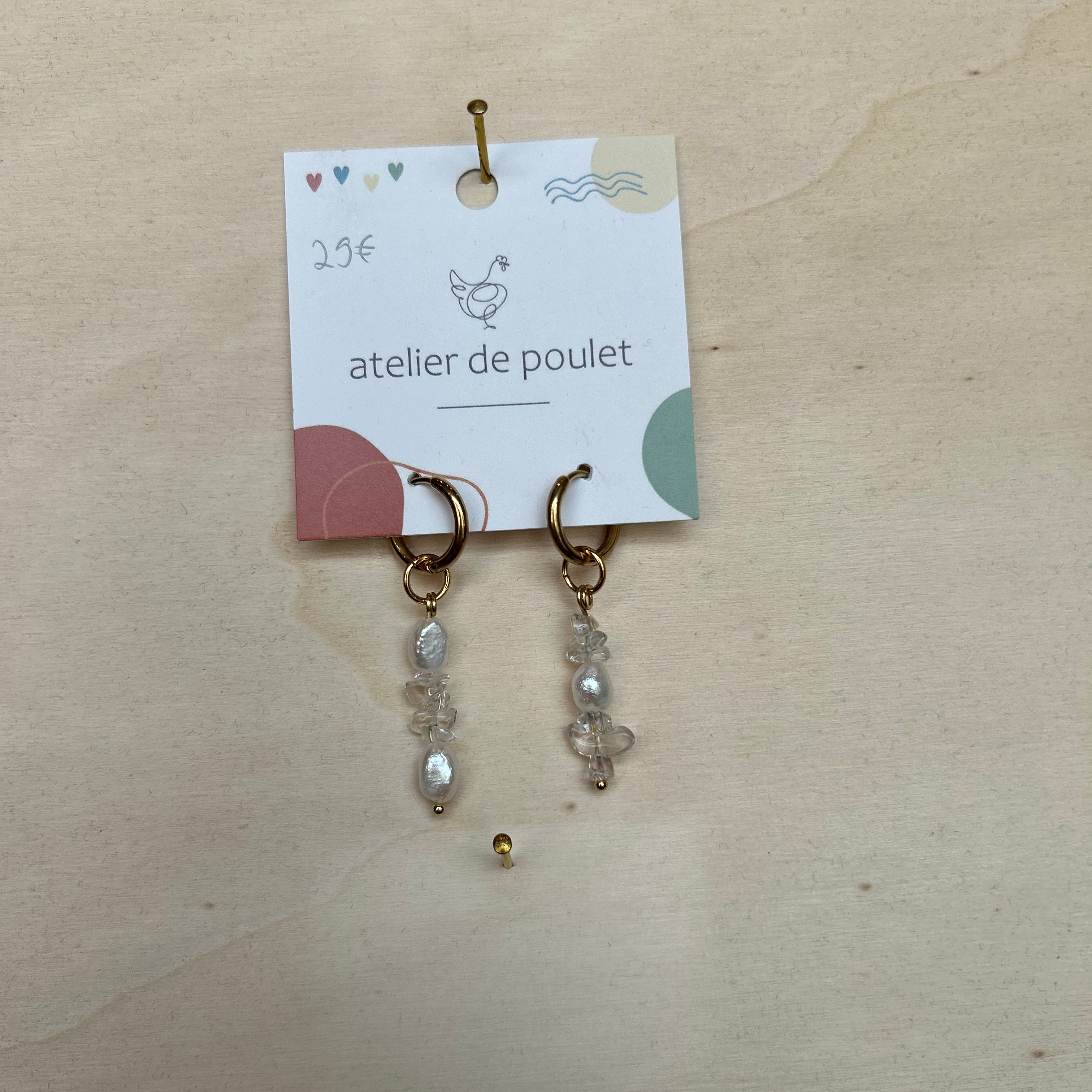 „Handgemachte Ohrringe von atelier de poulet – aus Edelsteinen und Perlen in der Farbe Weiß, präsentiert auf Holzdisplay. Stilvolle Damen-Ohrringe als individueller Modeschmuck, ideal als Geschenk oder Accessoire