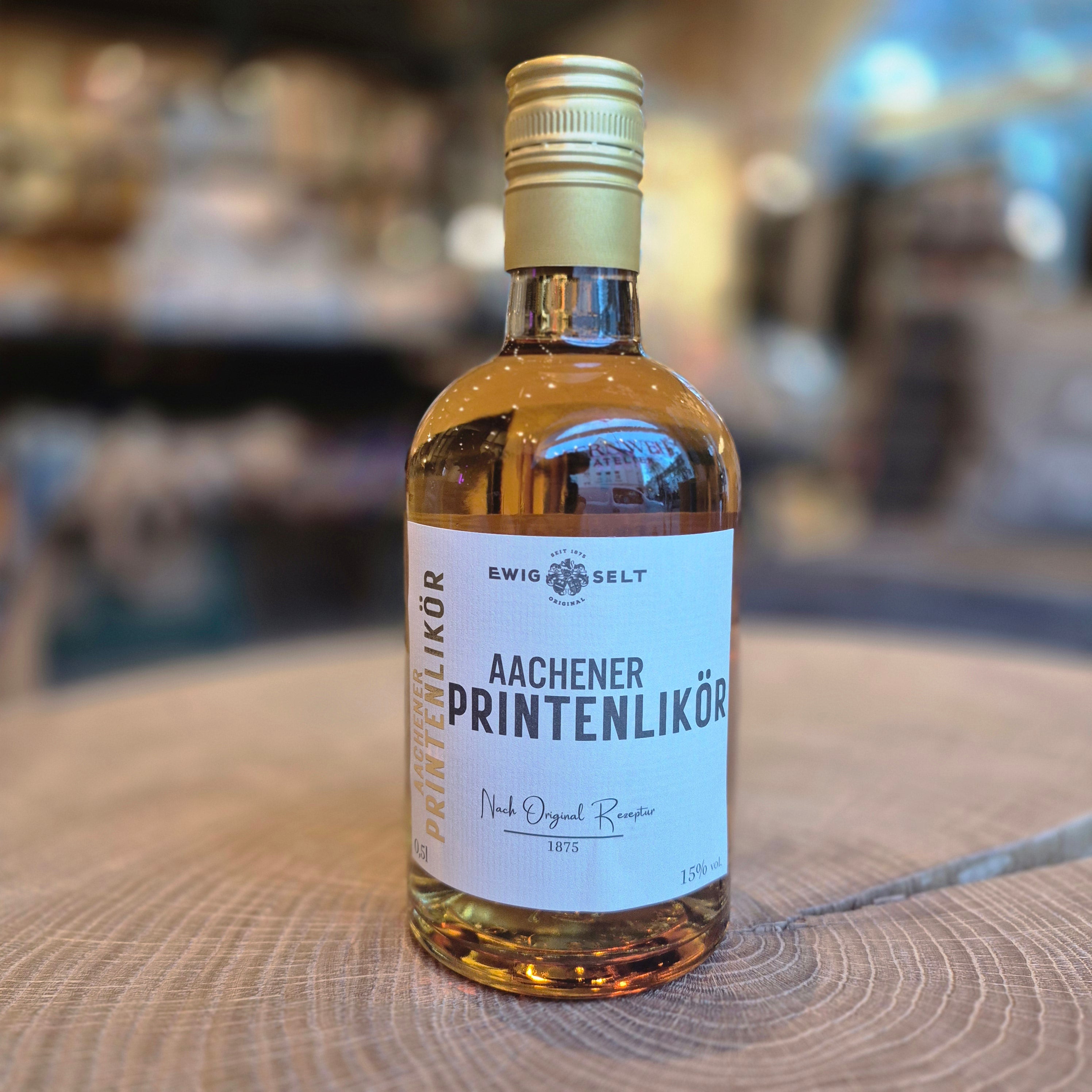 Ewig Selt Aachener Printenlikör 15 % vol. – 0,5-l-Flasche auf Holztisch. Traditioneller Likör aus Aachen nach Originalrezept von 1875 mit feinen Printengewürzen, Zimt, Honig und Karamell. Deutscher Gewürzlikör für Winter und Weihnachten