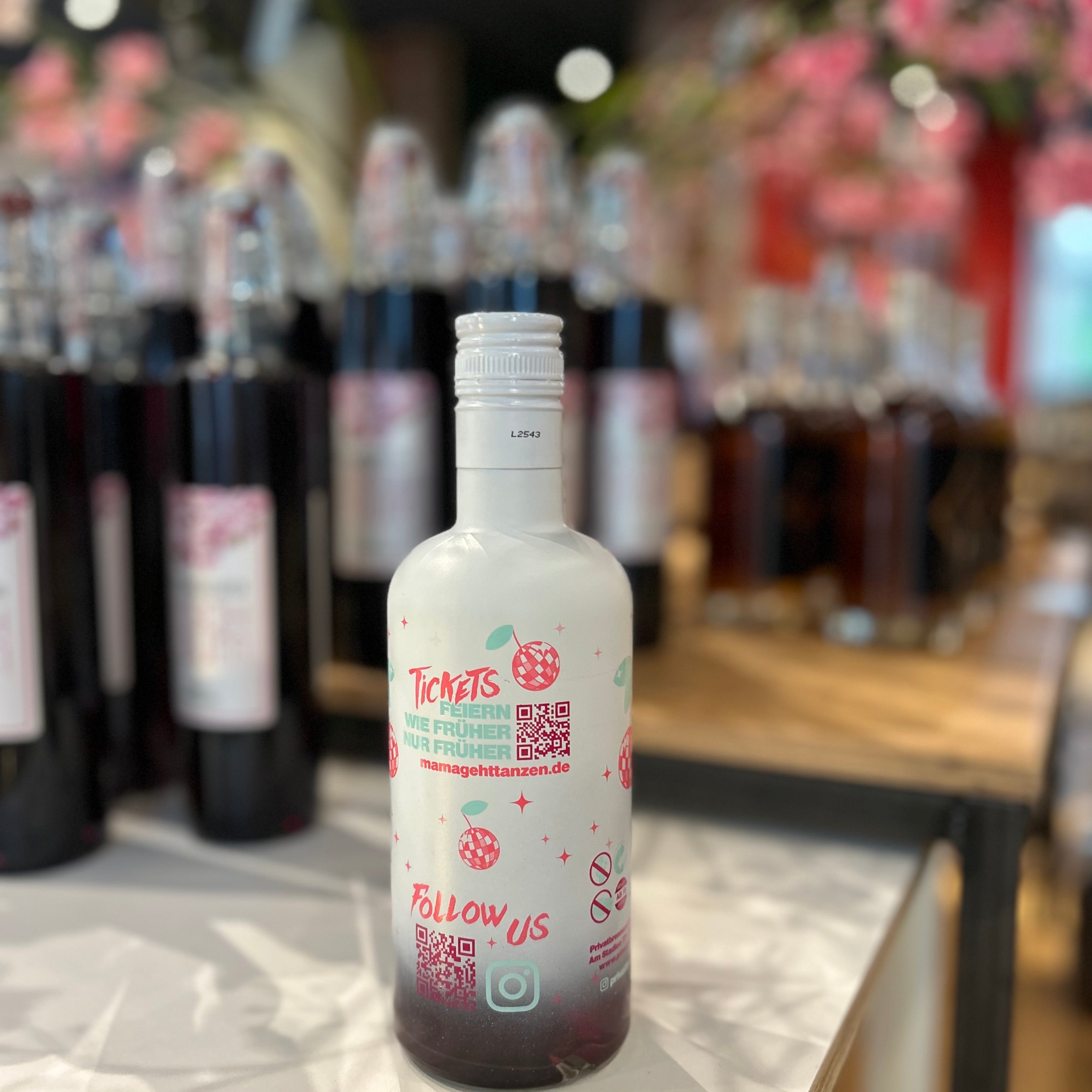 Ruby Kirsch Likör 15% Vol von Mama geht tanzen in 500ml Flasche – fruchtiger Kirschlikör mit intensivem Aroma, davon die Rückseite, stilvoll präsentiert im Regal, ideal als Geschenk oder zum Mixen von Cocktails.