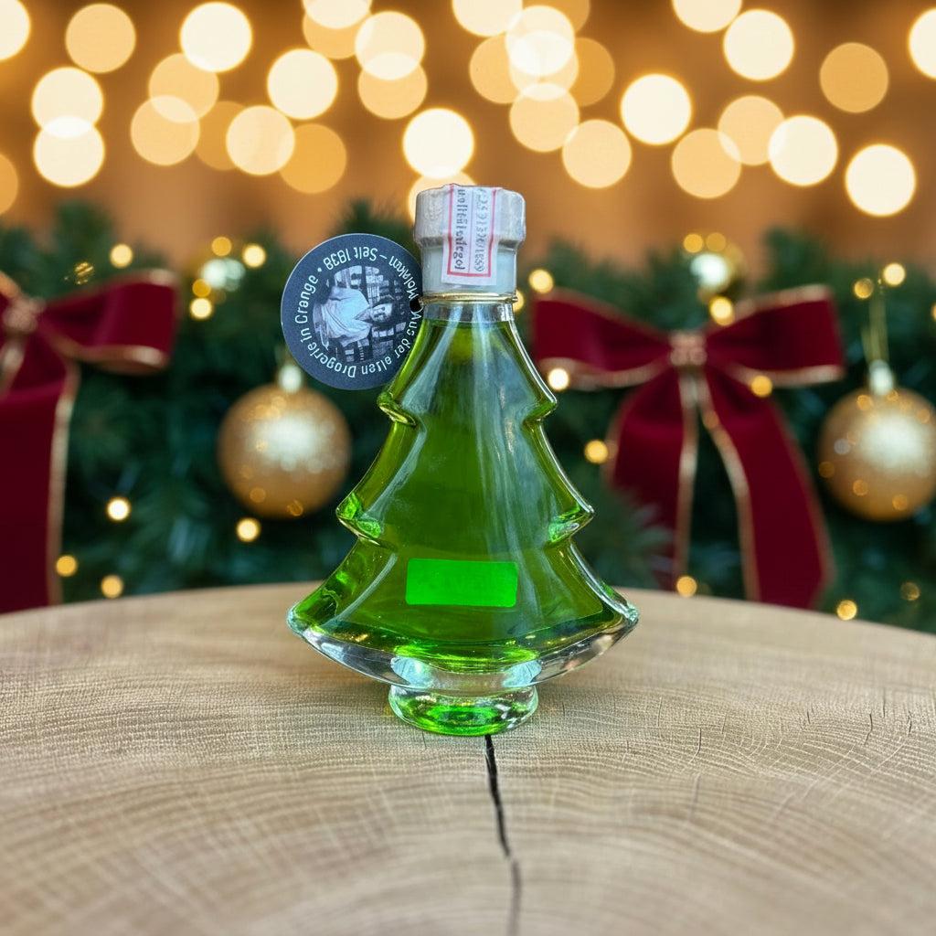 Grüne Likörflasche in Tannenbaumform, dekorativ auf einem Holztisch präsentiert. Weihnachtlicher Likör in besonderer Geschenkflasche aus Glas – ideal als Weihnachtsgeschenk, Wintergetränk oder festliches Mitbringsel. Hintergrund unscharf mit gemütlicher Ladenatmosphäre.