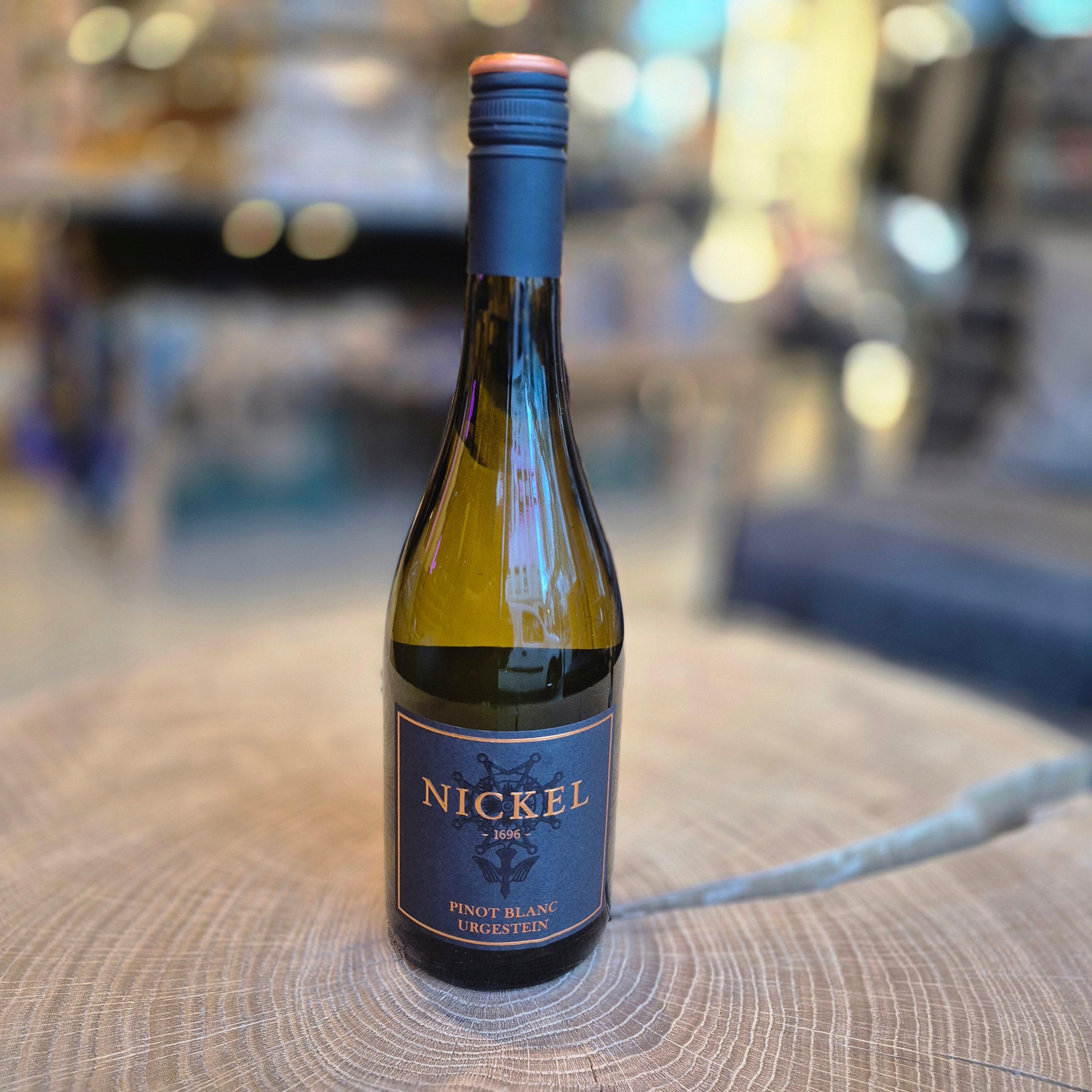 Nickel Pinot Blanc Urgestein – elegante Weißweinflasche auf Holztisch. Deutscher Pinot Blanc mit fruchtiger Frische und mineralischer Note, Qualitätswein vom Weingut Nickel, ideal zu Fisch, Geflügel und leichten Speisen.