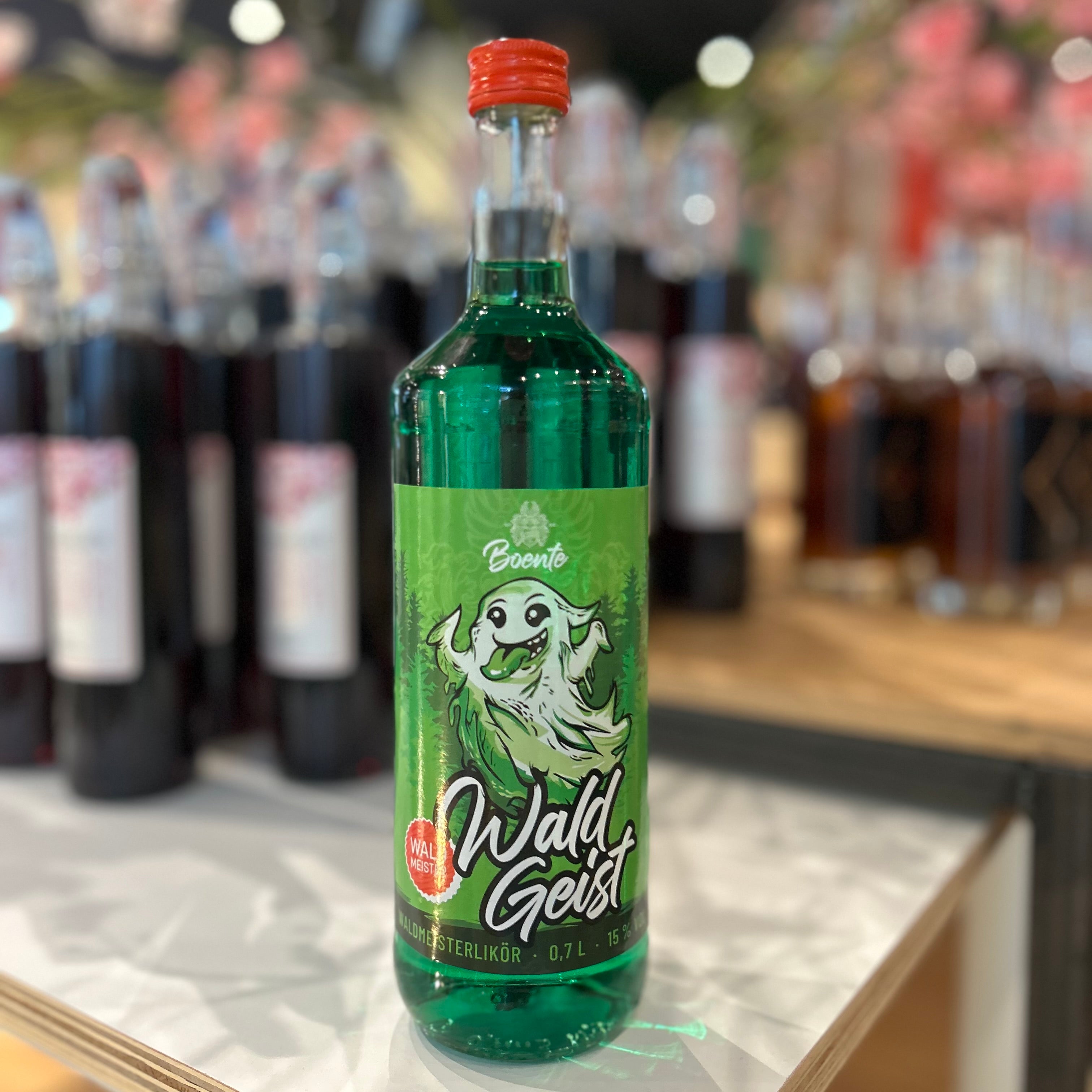 Wald Geist Waldmeister Likör 15% Vol in 0,7l Flasche von Boente – grüner Kräuterlikör mit intensivem Waldmeister-Geschmack, ideal für Partys, Cocktails oder als Geschenk, präsentiert im Regal.