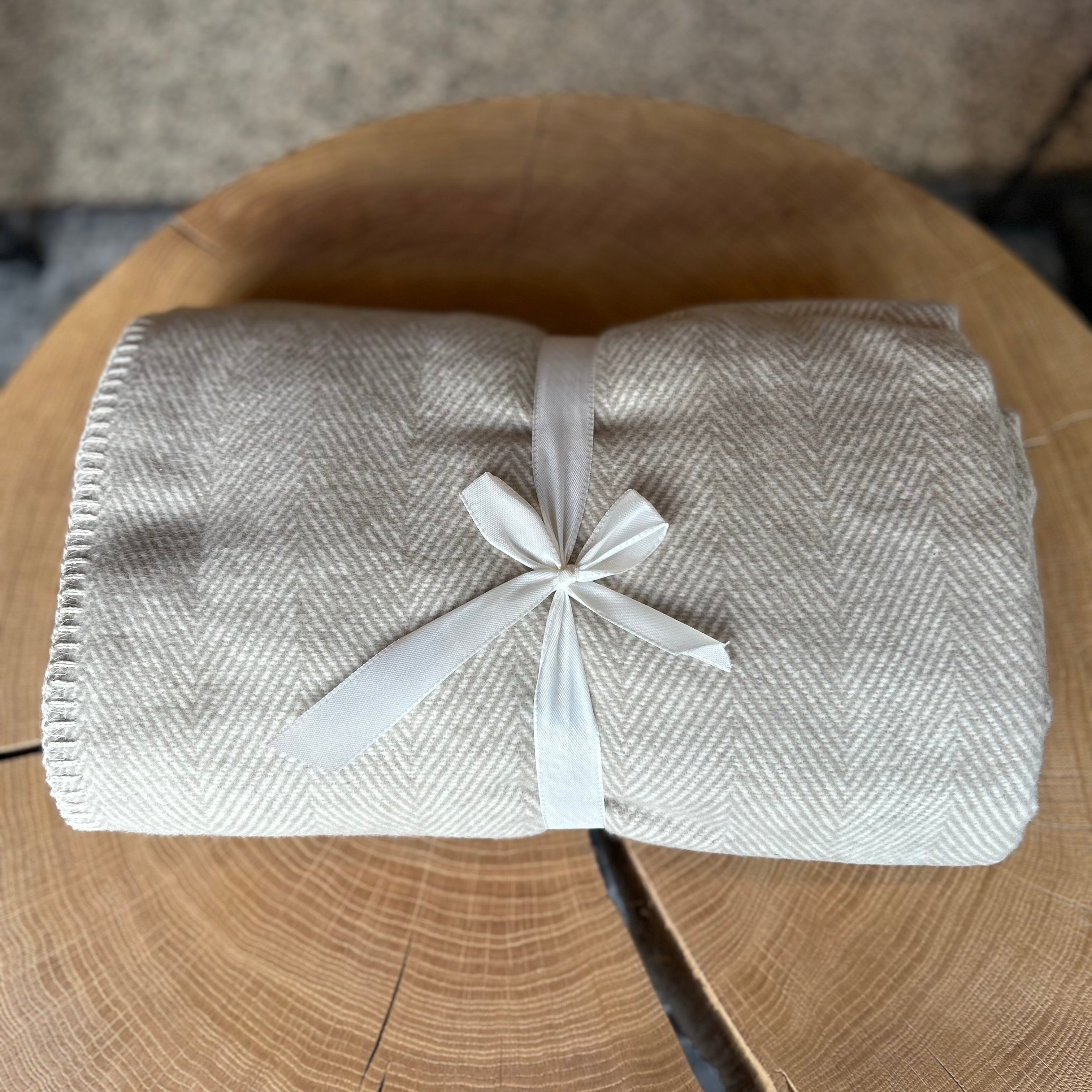 Weiche beige Decke aus 100 % Bio-Baumwolle – nachhaltige Kuscheldecke mit zartem Fischgrätenmuster, umweltfreundlich hergestellt, ideal für Sofa, Bett oder Babyzimmer, hautfreundlich und waschbar.