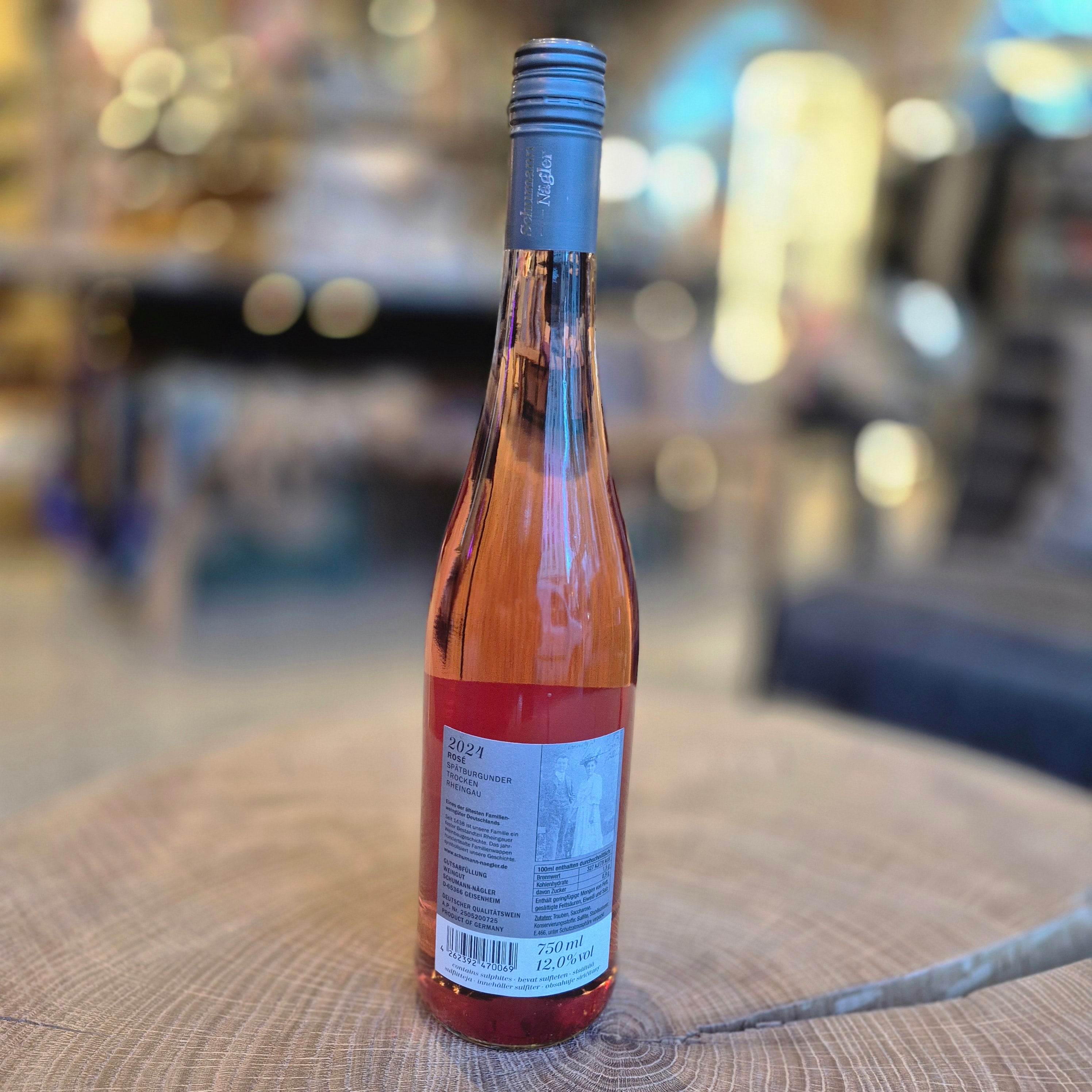 Schumann Nägler Spätburgunder Rosé trocken – elegante Weinflasche auf Holztisch. Deutscher Roséwein aus dem Rheingau mit fruchtigen Noten von Erdbeere und Himbeere, feiner Frische und harmonischer Struktur. Qualitätswein für Sommer und Genussmomente.