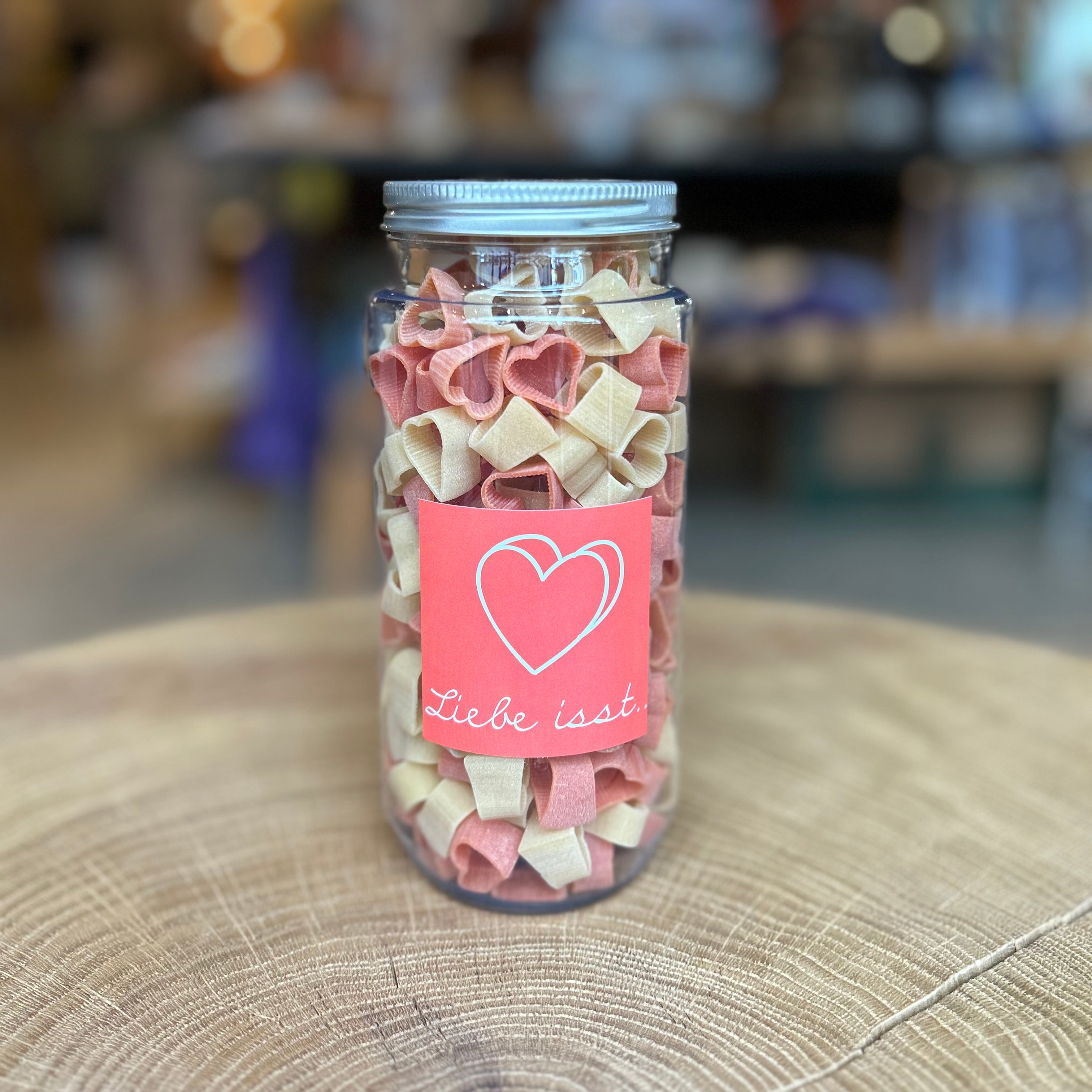 Herznudeln „Liebe isst“ im PET-Glas von Pütt Pasta – rote und naturfarbene Pasta in Herzform, 200 g, aus Hartweizengrieß, dekorativ verpackt, liebevolles Geschenk und nachhaltige Nudelspezialität aus dem Ruhrgebiet.