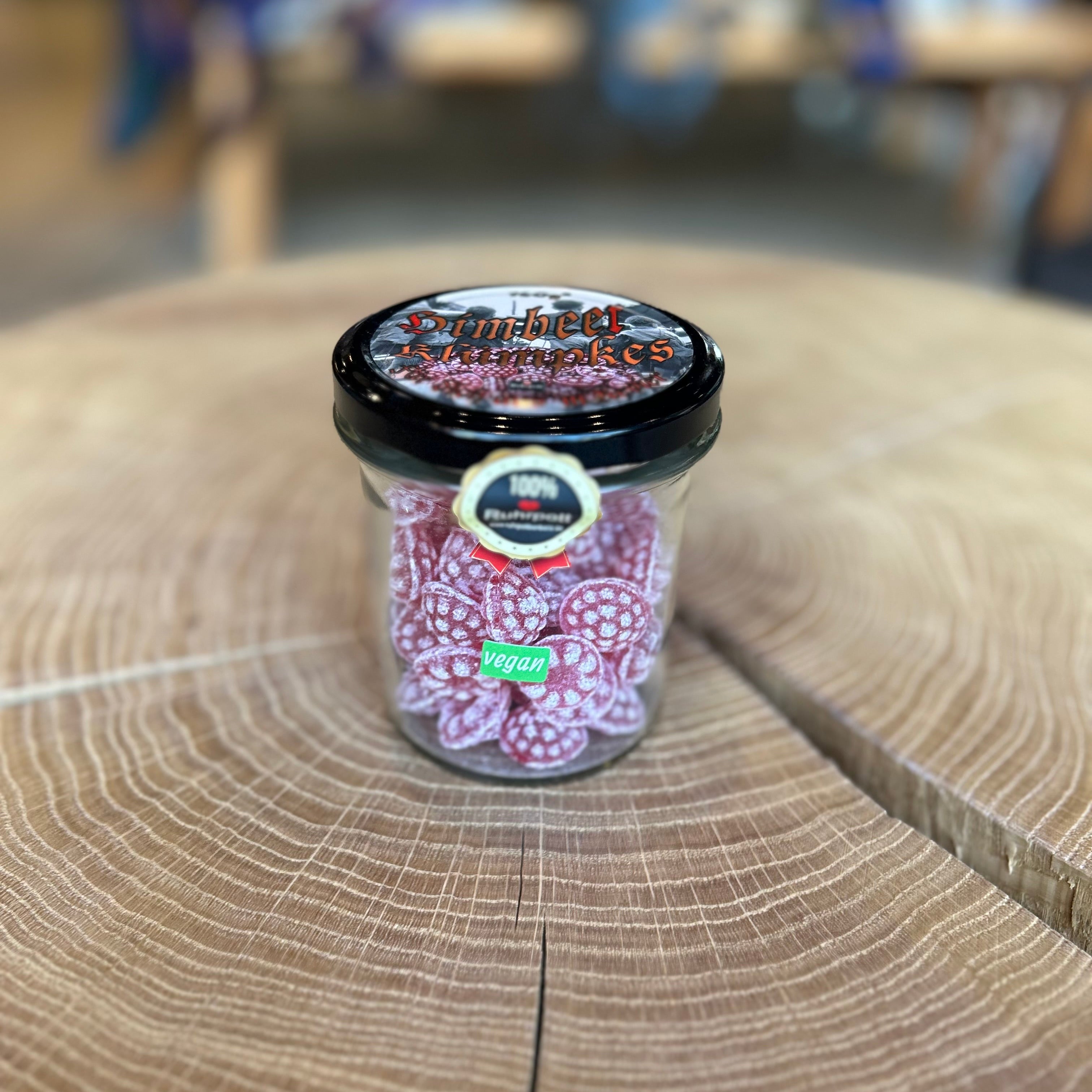 Glas mit veganen Himbeer Bonbons – traditionelle rote Himbeer-Süßigkeiten im Glas mit schwarzem Deckel, 100% Ruhrpott-Produkt, ideal als Geschenk oder Mitbringsel.