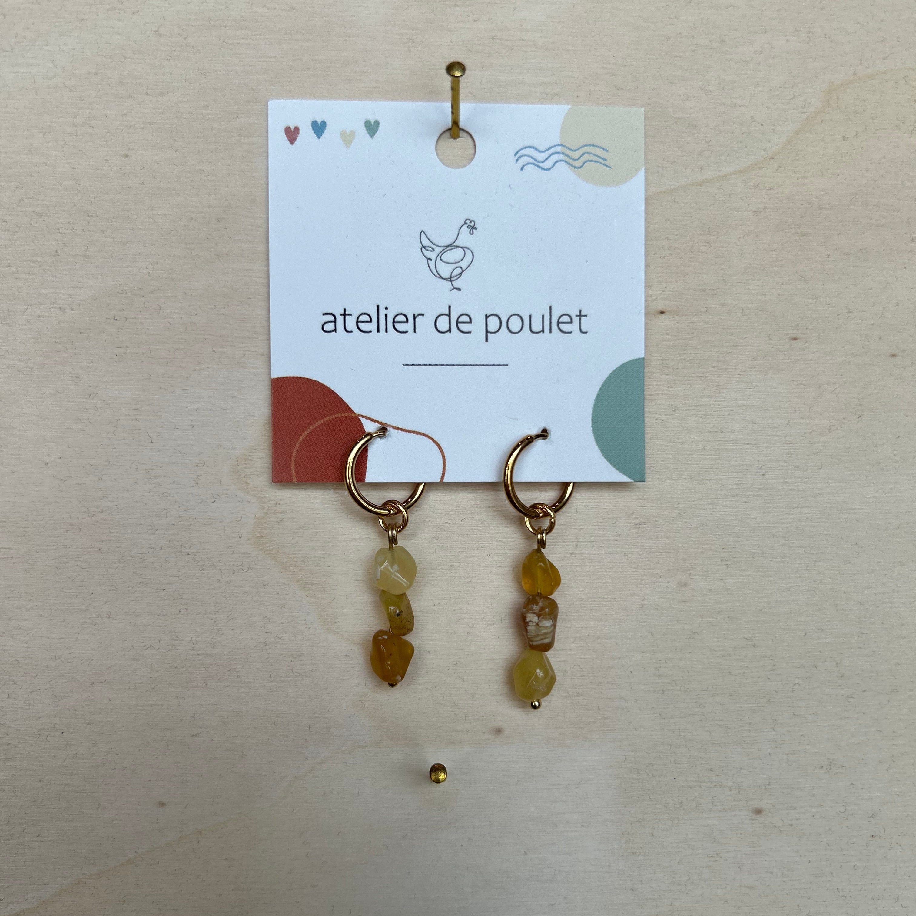 „Handgemachte Ohrringe von atelier de poulet – aus Edelsteinen in der Farbe Braun, präsentiert auf Holzdisplay. Stilvolle Damen-Ohrringe als individueller Modeschmuck, ideal als Geschenk oder Accessoire