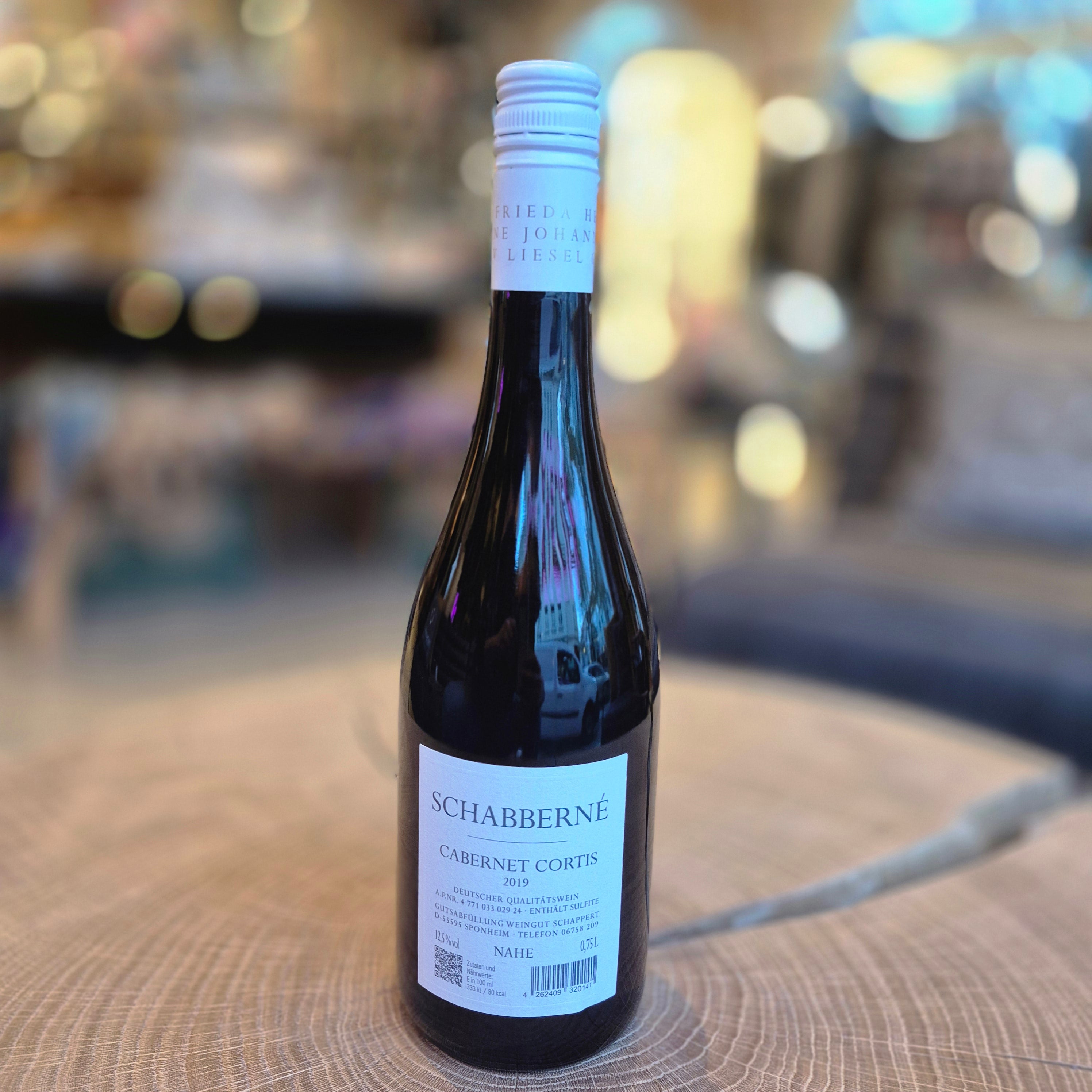 Schabberne Cabernet Cortis Rotwein 12,5 % vol. 0,75 l – elegante Weinflasche auf Holztisch. Deutscher Rotwein mit kräftigem Aroma, feinen Beerennoten und samtiger Struktur. Qualitätswein für Genießer und Rotweinliebhaber.
