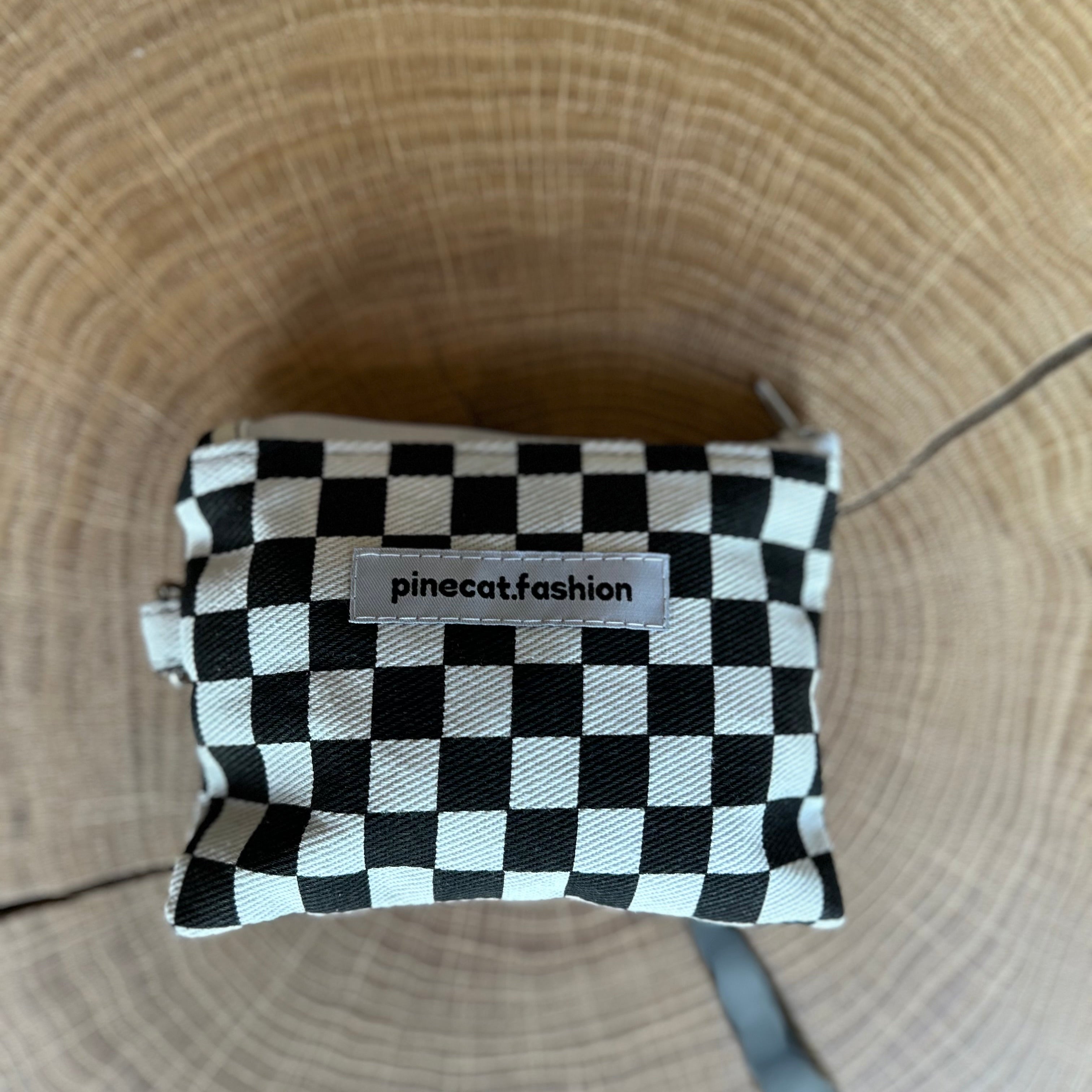 Schlüsseltasche von Pinecat in schwarz-weiß, liegt auf einem Holztisch