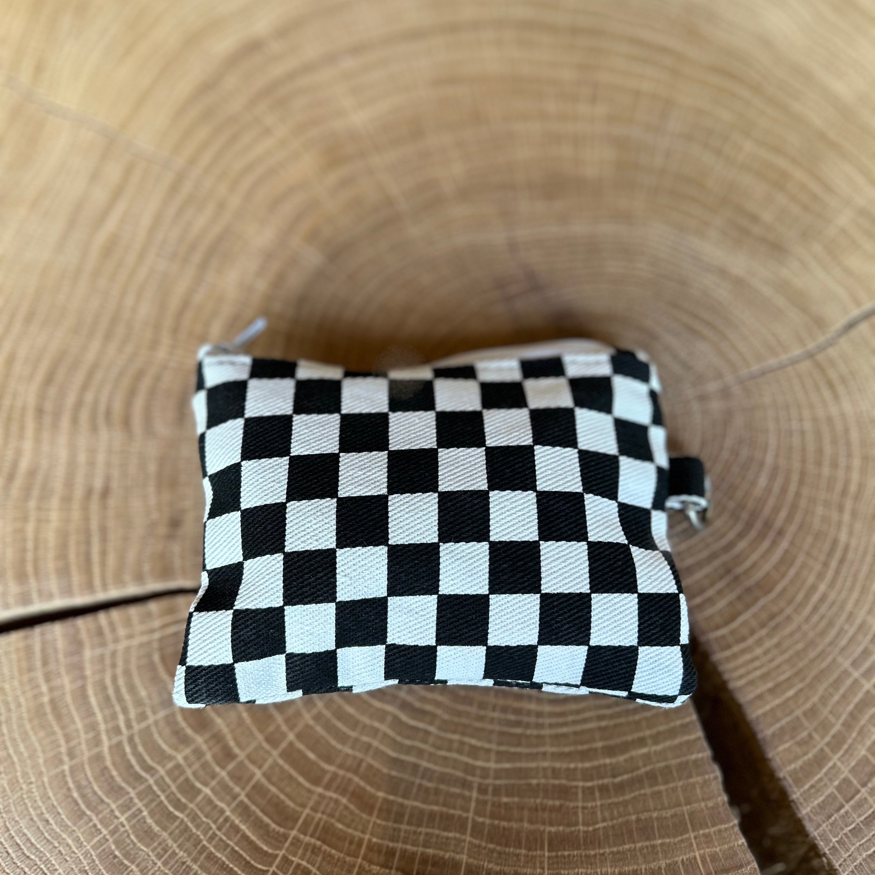 Schlüsseltasche von Pinecat in schwarz-weiß, liegt auf einem Holztisch