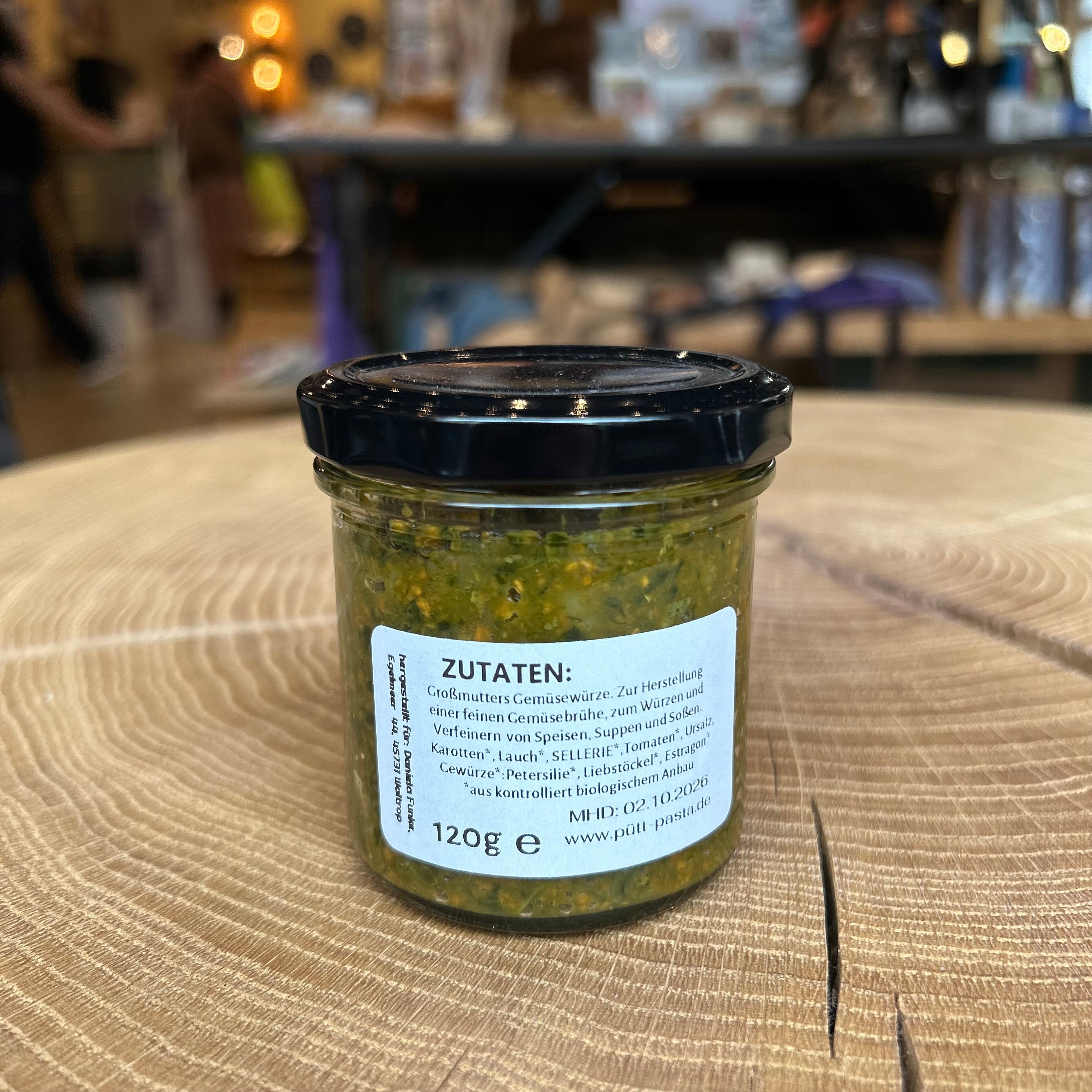 Glas mit Schnelle Kelle Gemüsewürze 120g von Pütt Pasta – aromatische Bio-Gemüsewürze aus natürlichen Zutaten, ideal zum Verfeinern von Suppen, Saucen und Gemüsegerichten. Nachhaltig hergestellt, im hochwertigen Glas mit schwarzem Deckel, fotografiert auf einem Holztisch. Perfekt für gesundes, würziges Kochen mit Produkten aus kontrolliert biologischem Anbau.