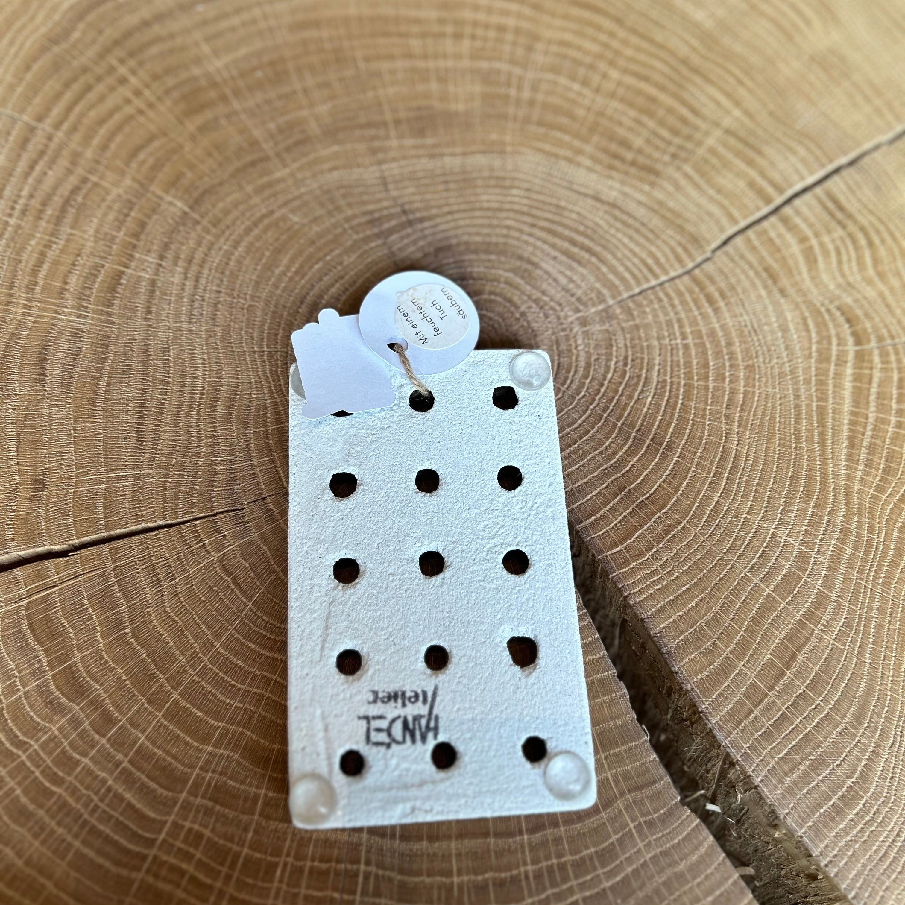 Rückseite einer Seifenablage aus Keramik in Weiß, liegt auf einem Holztisch