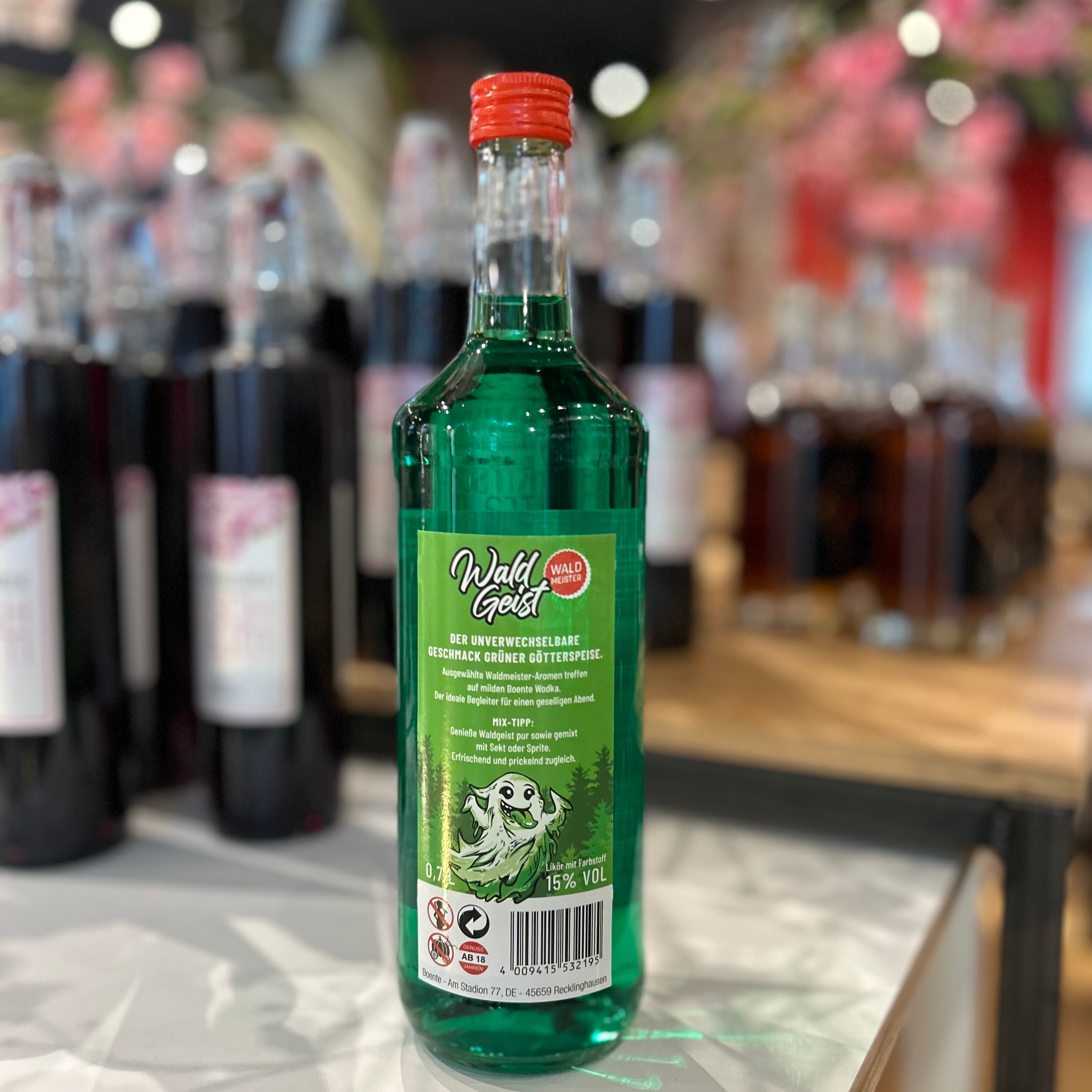 Wald Geist Waldmeister Likör 15% Vol in 0,7l Flasche von Boente – grüner Kräuterlikör mit intensivem Waldmeister-Geschmack, ideal für Partys, Cocktails oder als Geschenk, Flasche von hinten, präsentiert im Regal.